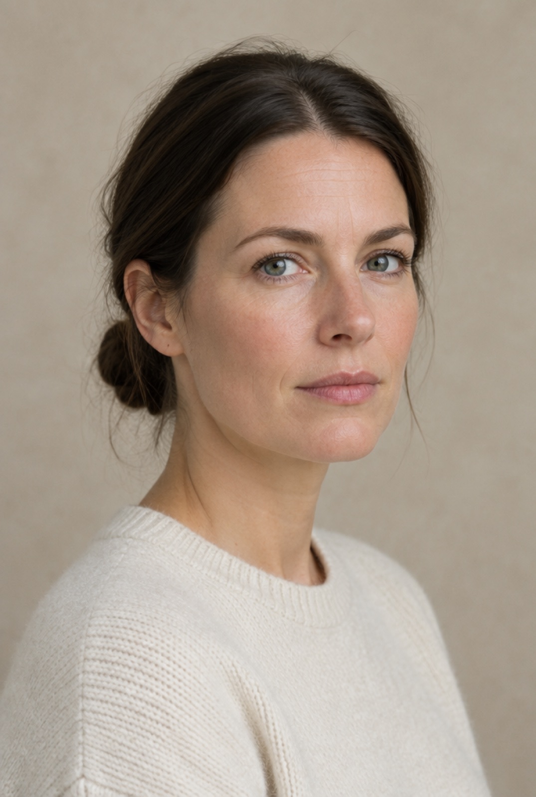 Mette Kjær, a woman with dark hair in a low bun, calm expression